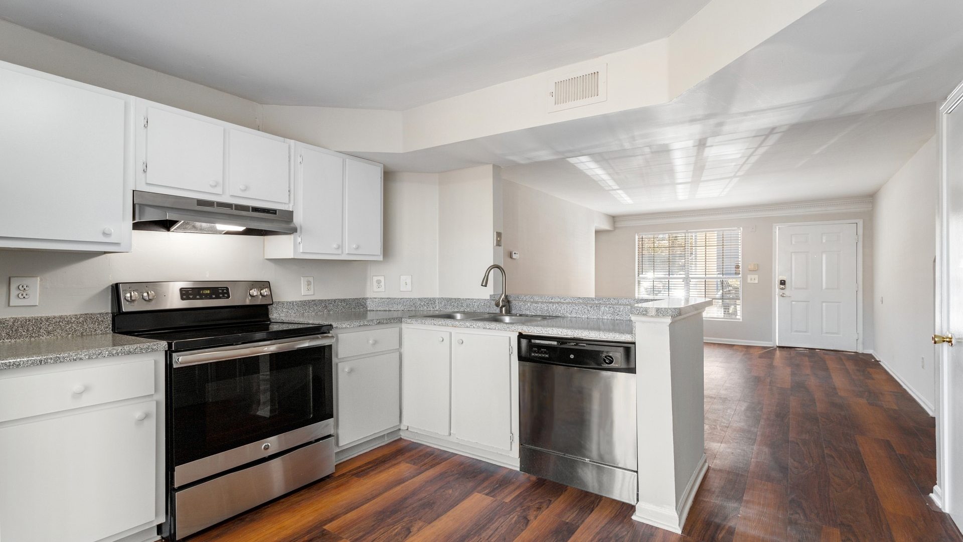 a kitchen with white cabinets and stainless steel appliances at The Peachtree Park